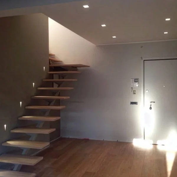 Scala sospesa in legno con parete in cartongesso in ambiente interno moderno
