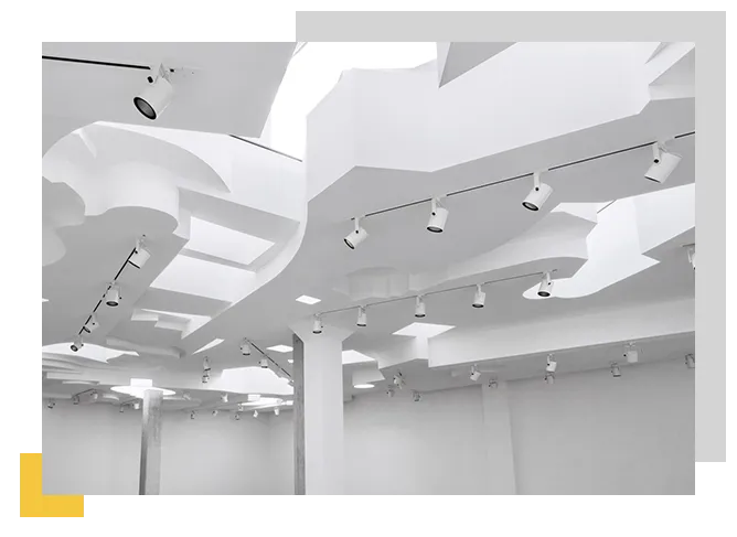 Sistema di controsoffitto tecnico con integrazione impiantistica e corpi illuminanti in ambiente commerciale